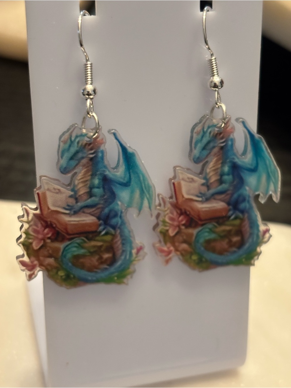 Title: Blue Dragon Reading Acrylic Dangle Earrings | Dragon Sitting On Rock With